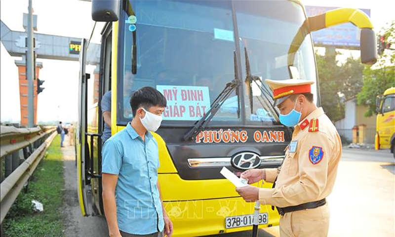 CSGT Trạm Quốc lộ 1A kiểm tra giấy tờ, bằng lái và hàng hóa của xe khách. Ảnh tư liệu: Minh Đức/TTXVN