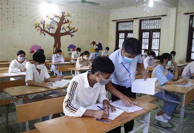 Giám thị hướng dẫn cho thí sinh điền thông tin cá nhân vào bài thi. (Ảnh: Đinh Thùy/TTXVN)