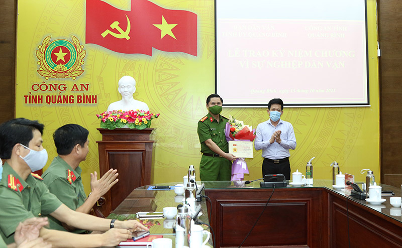 Đồng chí Trưởng ban Dân vận Tỉnh ủy Lê Văn Bảo trao kỷ niệm chương Vì sự nghiệp Dân vận của Đảng cho đồng chíĐại tá Nguyễn Tiến Hoàng Anh, Phó Giám đốc Công an tỉnh Quảng Bình. 