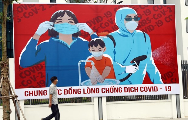 Tấm biển tuyên truyền phòng, chống COVID-19 trên đường phố Hà Nội. (Ảnh: Huy Hùng/TTXVN)