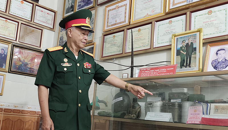 Ông Hồ Duy Thiện đang kể về các hiện vật trong bảo tàng.