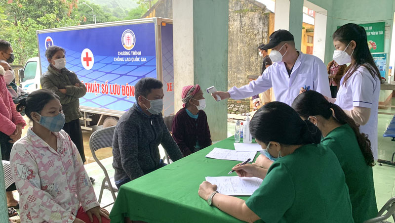 Đo thân nhiệt và tư vấn cho người dân trước khi vào khám sàng lọc bệnh lao.