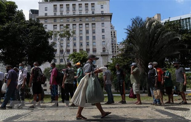 Người vô gia cư xếp hàng chờ nhận bữa ăn miễn phí tại Sao Paulo, Brazil. (Ảnh: AFP/TTXVN)