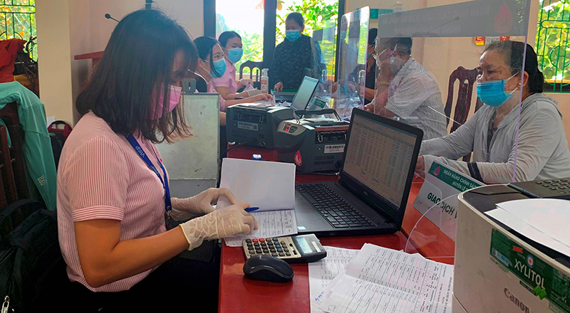 Người dân đến giao dịch, gửi tiền tiết kiệm tại điểm giao dịch xã Sơn Thủy (Lệ Thủy).