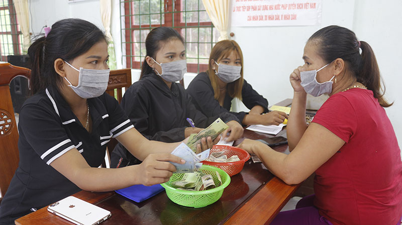 Các thành viên Tổ TK-TD bản Kè đóng dấu nộp tiền tiết kiệm.