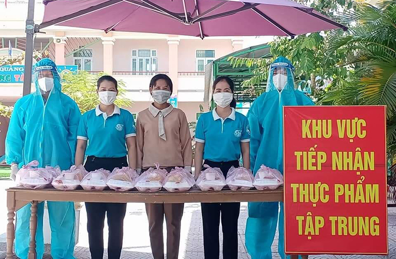 Phụ nữ huyện trao các suất ăn cho bà con ở khu cách ly.
