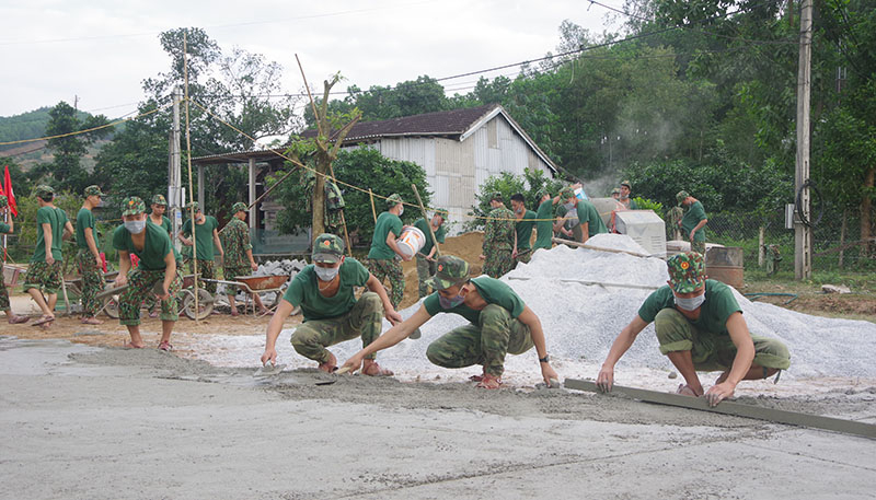 Cán bộ, chiến sỹ LLVT tỉnh tham gia làm đường bê tông ở xã Thạch Hóa (Tuyên Hóa).