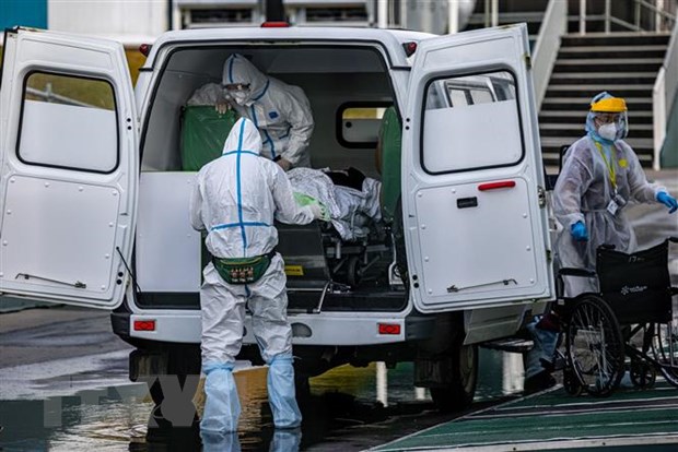 Nhân viên y tế chuyển bệnh nhân COVID-19 tới bệnh viện ở ngoại ô Moskva, Nga. (Ảnh: AFP/TTXVN)