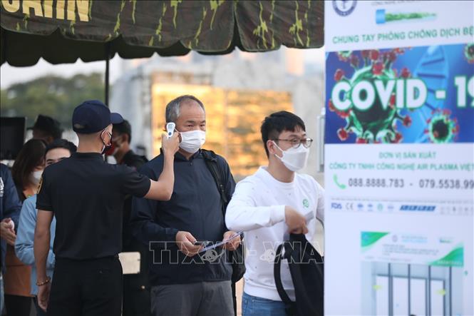 Người dân tuân thủ khẩu trang phòng dịch COVID-19 khi đến nơi công cộng. Ảnh: TTXVN