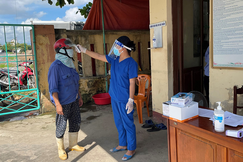Lực lượng chức năng kiểm tra thân nhiệt, khai báo y tế người lao động trước khi vào cảng cá Nhật Lệ.
