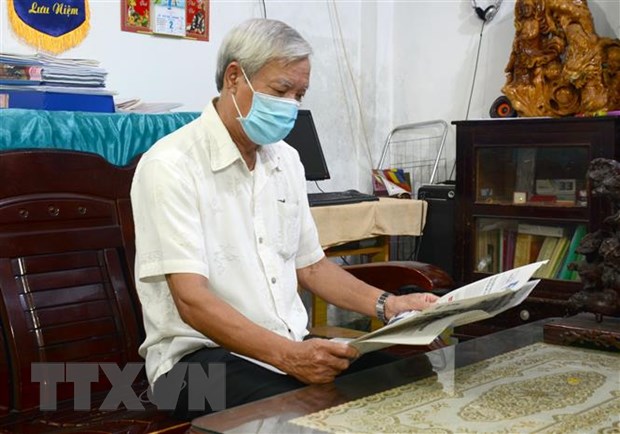Ông Trần Mạnh (Bí thư chi bộ Hải Học 4, phường Hải Châu 2, quận Hải Châu, thành phố Đà Nẵng) đọc Quy định số 41-QĐ/TW trên báo. (Ảnh: Quốc Dũng/TTXVN)