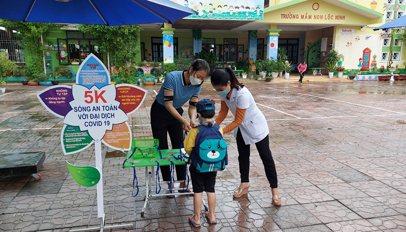 Trẻ được kiểm tra thân nhiệt và sát khuẩn tay trước khi vào trường.