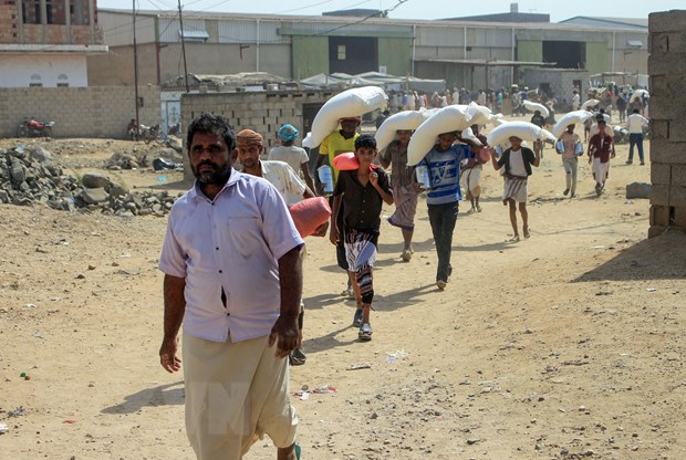  Người dân nhận lương thực cứu trợ tại tỉnh Hajjah, Yemen, ngày 12-1-2021. (Ảnh: AFP/TTXVN)