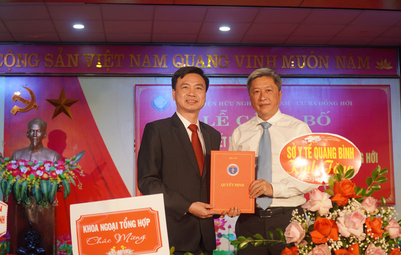 Thứ trưởng Bộ Y tế Nguyễn Trường Sơn trao quyết định và tặng hoa chúc mừng Giám đốc Bệnh viện Hữu nghị Việt Nam - Cu Ba Đồng Hới Nguyễn Đức Cường. 