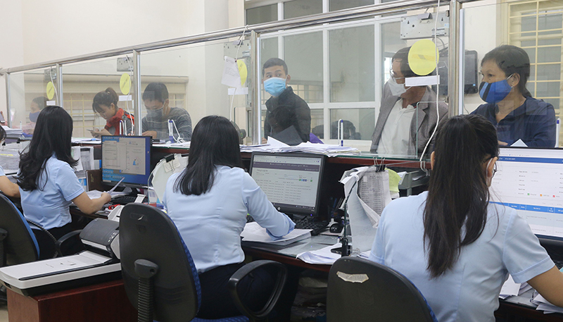 Cán bộ BHXH tỉnh Quảng Bình tư vấn, hướng dẫn người dân các thủ tục, chính sách liên quan đến BHXH, BHYT. 