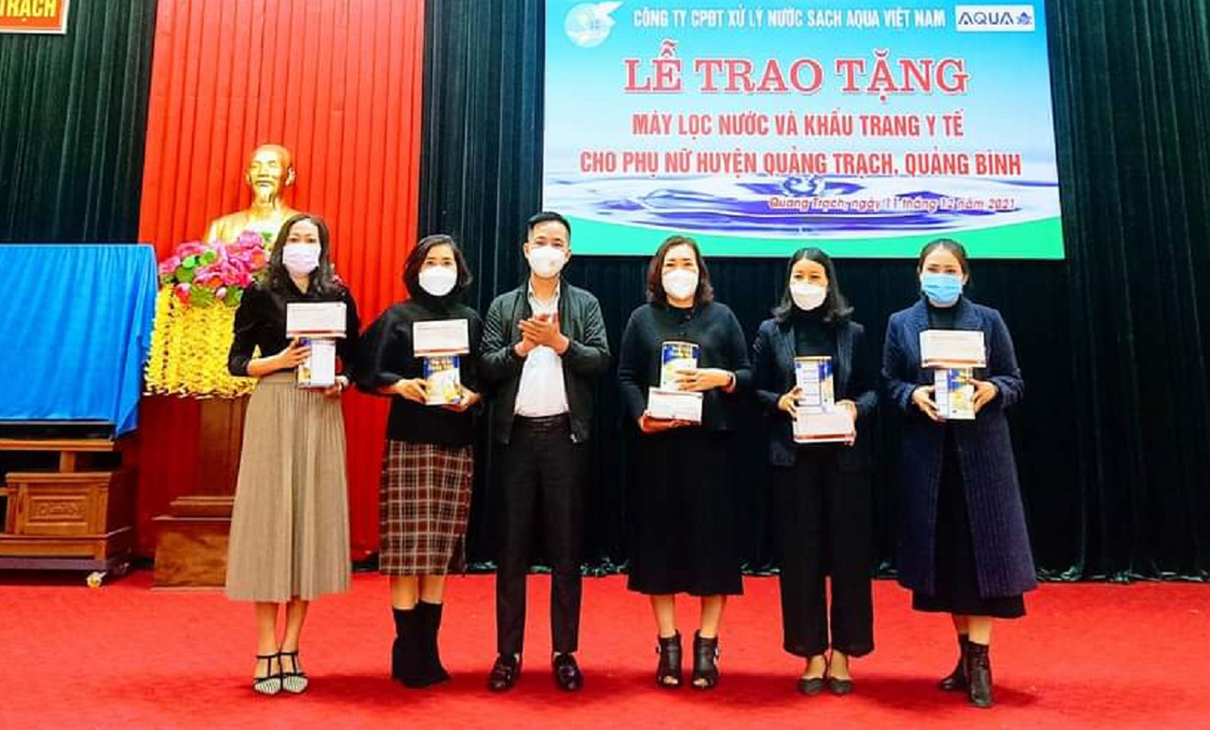 Đại diện Công ty Cổ phần Đầu tư xử lý nước sạch AQua Việt Nam trao khẩu trang và sữa cho hội viên Hội LHPN huyện Quảng Trạch.