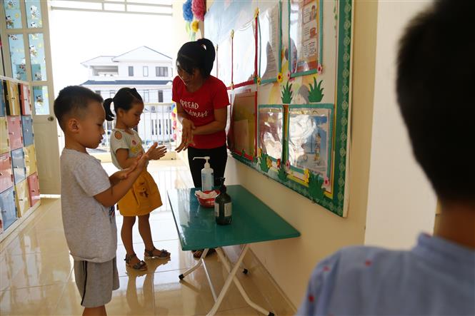  Cô giáo phụ trách lớp hướng dẫn các bé rửa tay sát khuẩn. Ảnh: Nam Sương/TTXVN.