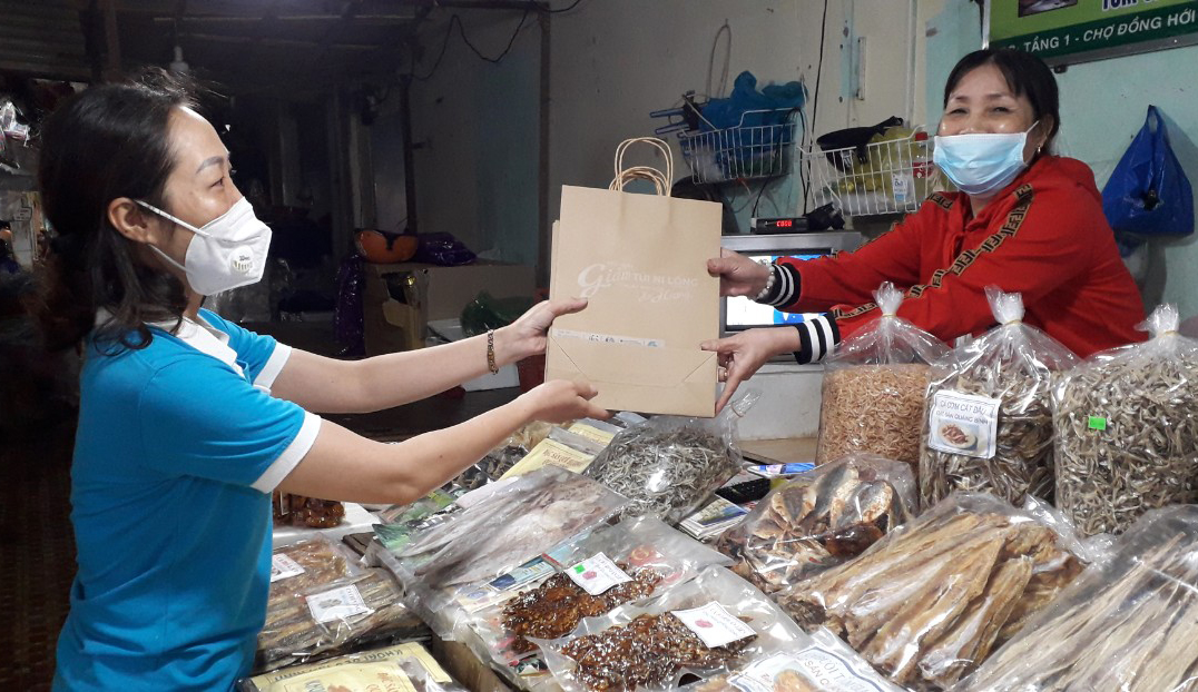Tặng túi giấy thay thế túi ni lông cho tiểu thương Chợ Đồng Hới.