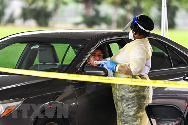 Nhân viên y tế lấy mẫu xét nghiệm COVID-19 cho người dân ở Miami, bang Florida, Mỹ. (Ảnh: AFP/TTXVN)