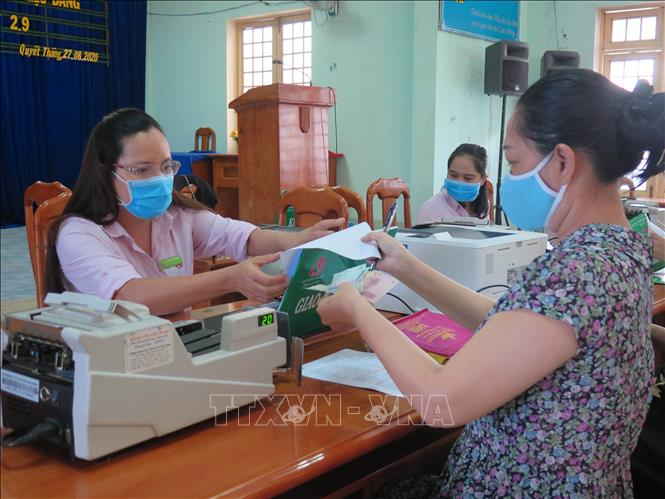  Người dân phường Quyết Thắng, thành phố Kon Tum làm thủ tục nhận tiền vay vốn tín dụng chính sách.  Ảnh: TTXVN