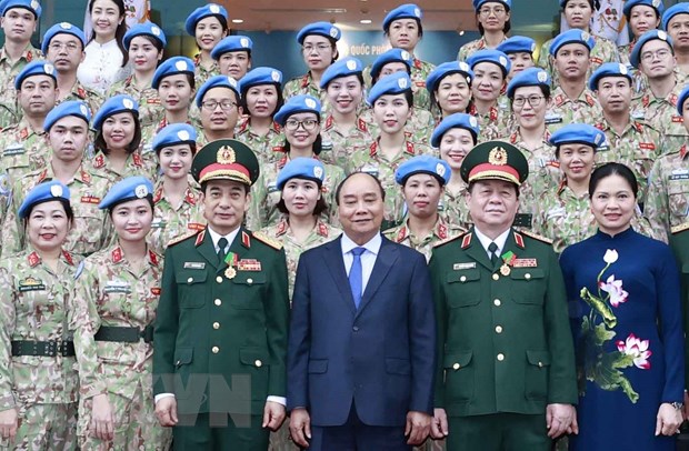 Chủ tịch nước Nguyễn Xuân Phúc, Bộ trưởng Bộ Quốc phòng, Đại tướng Phan Văn Giang, Trưởng ban Tuyên giáo Trung ương Nguyễn Trọng Nghĩa chụp ảnh cùng lực lượng gìn giữ hòa bình của Việt Nam đã hoàn thành xuất sắc nhiệm vụ. (Ảnh: Thống Nhất/TTXVN)