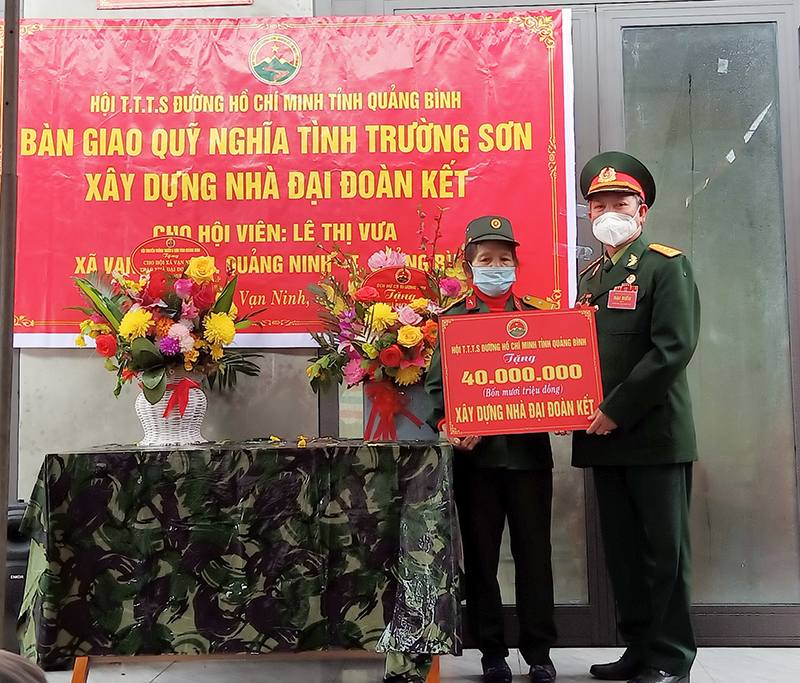 Đại diện Hội truyền thống Trường Sơn đường Hồ Chí Minh tỉnh Quảng Bình trao số tiền hỗ trợ cho hộ bà Lê Thị Vưa ở thôn Áng Sơn, xã Vạn Ninh, huyện Quảng Ninh.