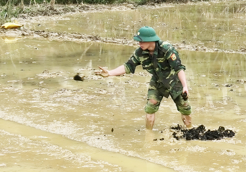 Cán bộ chiến sỹ Đồn BP Cà Xèng giúp dân bón phân