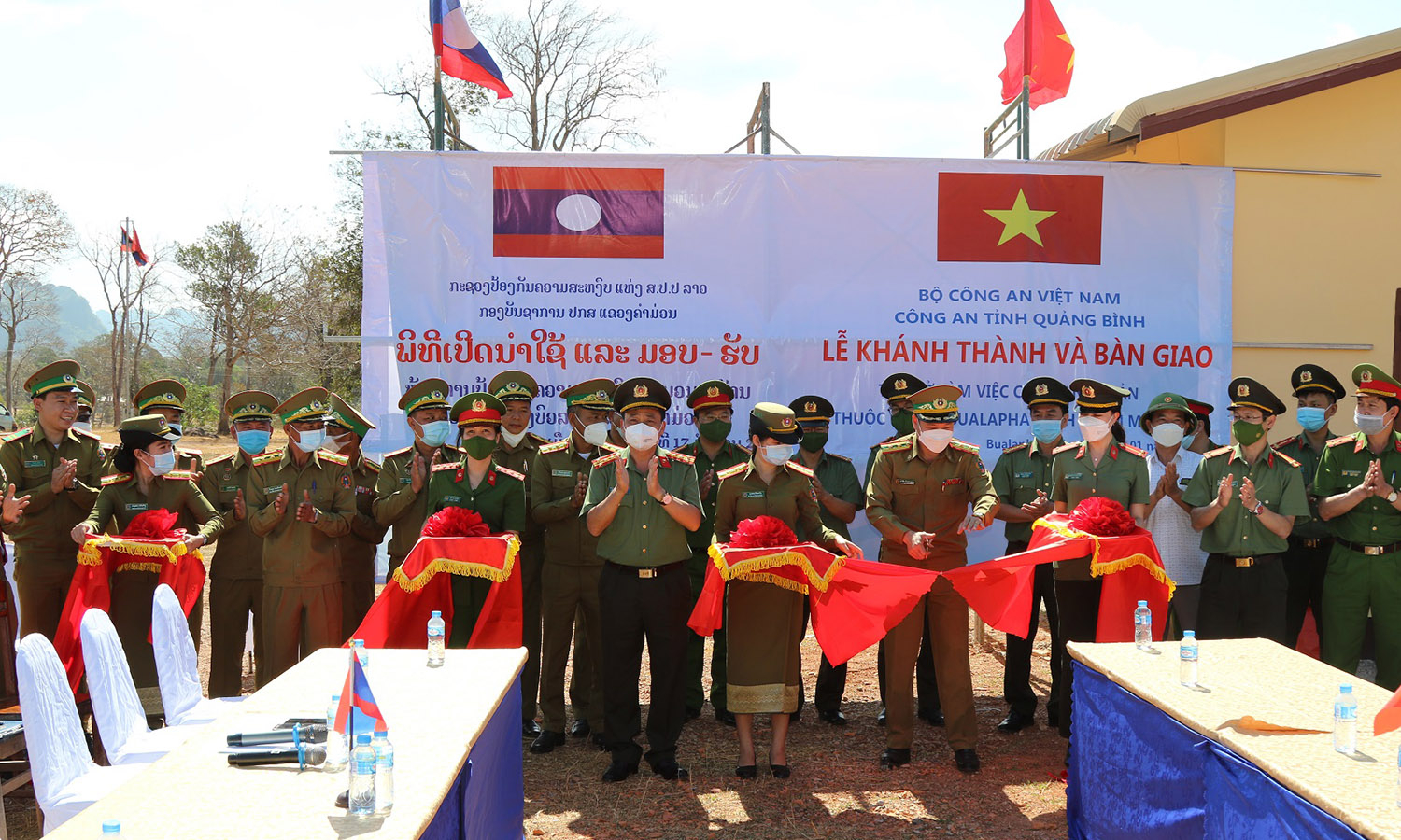 Đại tá Lê Văn Hóa, Phó Giám đốc Công an tỉnh Quảng Bình và Thượng tá Khăm Xỉn Nôn Tha Son, Phó Giám đốc Công an tỉnh Khăm Muộn cắt băng khánh thành tại lễ bàn giao.