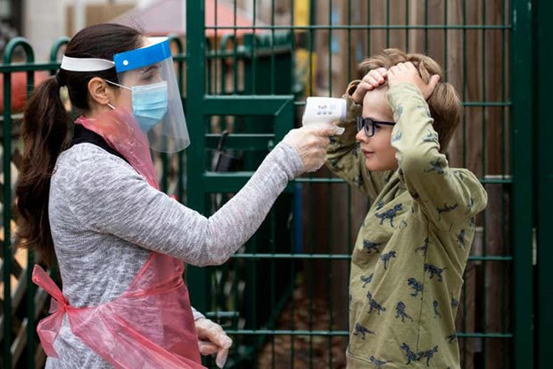 Nhân viên y tế đo nhiệt độ cho trẻ em. (Nguồn: Getty Images)