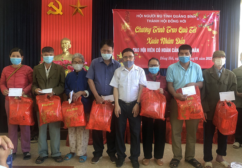 Các cán bộ, nhân viên Hội Người mù thành phố Đồng Hới vui mừng đón nhận quà tết do Hội trao tặng.