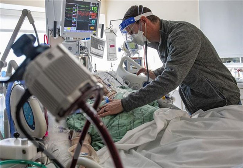 Nhân viên y tế điều trị cho bệnh nhân COVID-19. (Ảnh: AFP/TTXVN)
