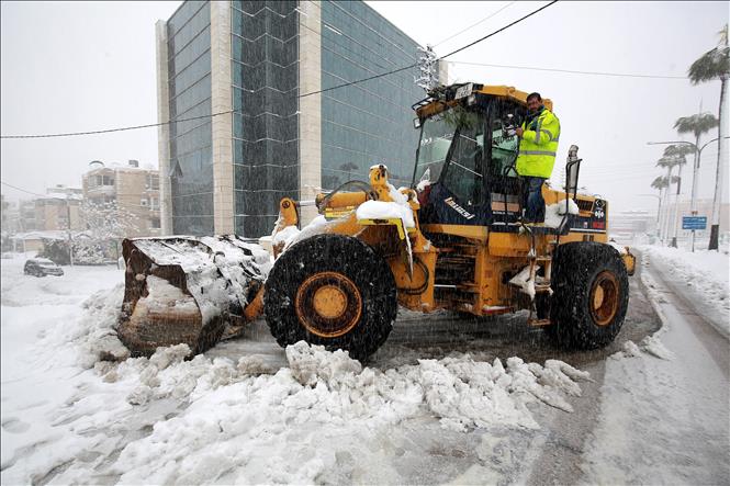 Công nhân dọn tuyết trên đường phố tại Amman, Jordan, ngày 27/1/2022. Ảnh: AFP/TTXVN ADVERTISING
