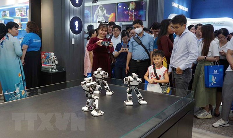 Khách tham quan khu vực trưng bày các giải pháp ứng dụng công nghệ thông tin, trí tuệ nhân tạo. (Ảnh: TTXVN)