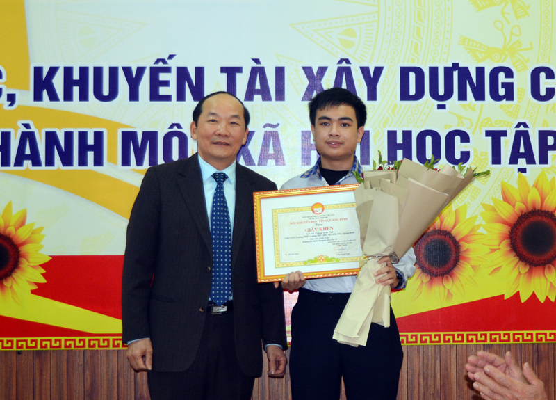 Chủ tịch Hội Khuyến học tỉnh Trần Xuân Vinh trao giấy khen, tiền thưởng chúc mừng em Trương Quốc Thái.
