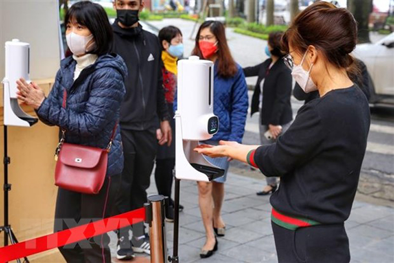 Học sinh sát khuẩn và đo thân nhiệt trước khi vào trường. (Ảnh: Tuấn Đức/TTXVN)