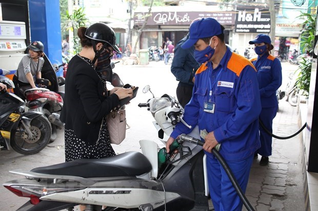  Nhân viên Petrolimex đang bán xăng cho khách hàng. (Ảnh: Đức Duy/Vietnam+)