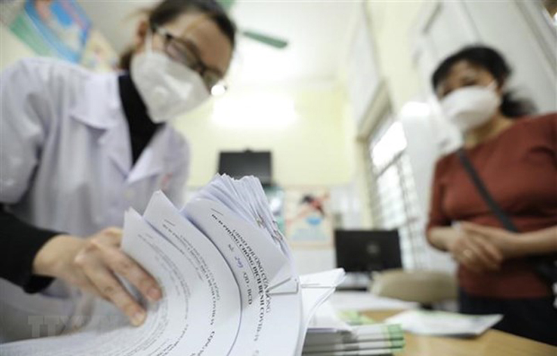 Giấy chứng nhận khỏi COVID-19 được trạm y tế phường thông báo cho tổ trưởng tổ dân phố đến nhận và phát tại nhà cho các bệnh nhân F0 khỏi bệnh. (Ảnh: Minh Quyết/TTXVN)