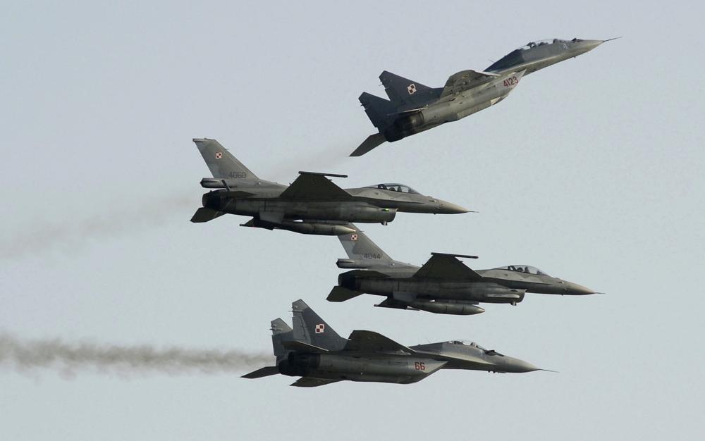 Hai máy bay thời Liên Xô Mig-29 bay phía trên và hai máy bay F-16 do Mỹ sản xuất tại Triển lãm Hàng không ở Radom, Ba Lan, ngày 27/8/2011. Ảnh AP 
