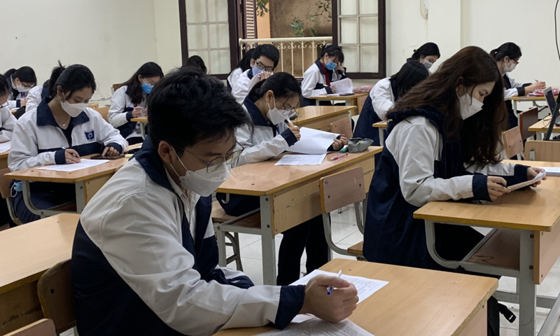 Học sinh lớp 12 đi học khi số ca nhiễm COVID-19 trong nhà trường liên tục tăng. Ảnh: Lê Vân 