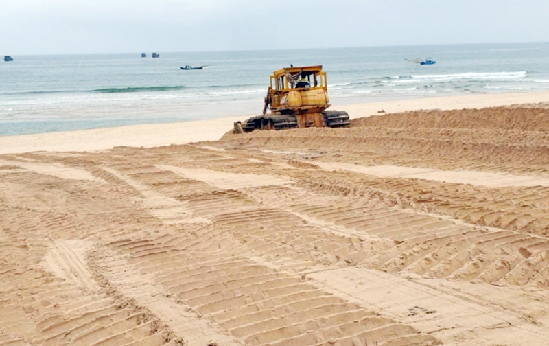 BQL Dịch vụ công ích TP. Đồng Hới huy động công nhân và máy móc thiết bị để san, gạt và dọn vệ sinh các bãi tắm trên địa bàn thành phố.