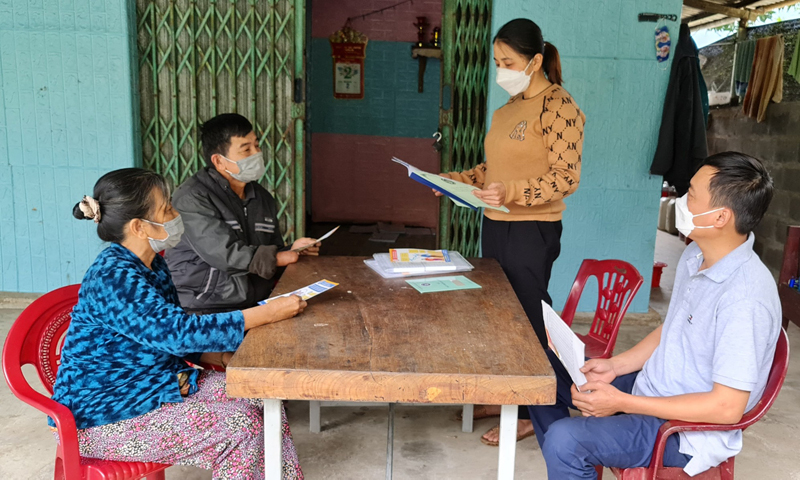 Chị Trần Thị Thúy Hà (người đứng) đến tận từng nhà để tuyên truyền chính sách BHXH đến với người dân.
