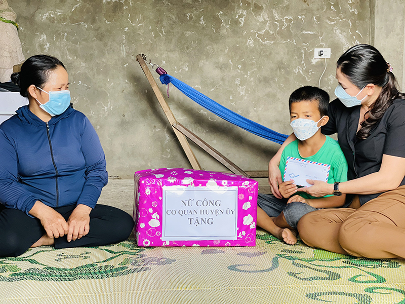 Đại diện Ban Nữ công cơ quan Huyện ủy Bố Trạch tặng quà hỗ trợ, động viên cháu Phan Anh Tuấn.