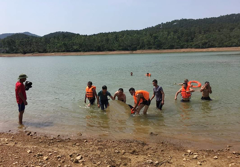 Lực lượng chức năng và bà con nhân dân xã Hạ Trạch (Bố Trạch) đưa thi thể ông T vào bờ. 