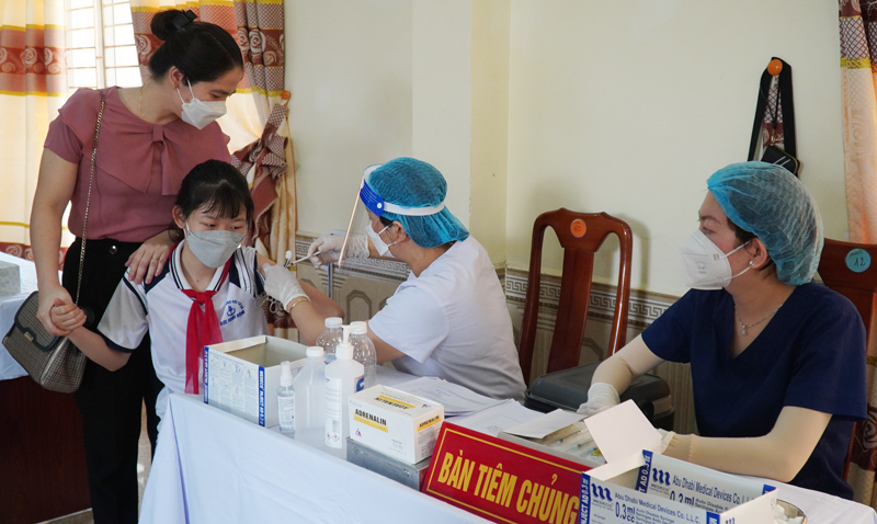Phụ huynh đồng hành với các con trong mũi tiêm đầu tiên.