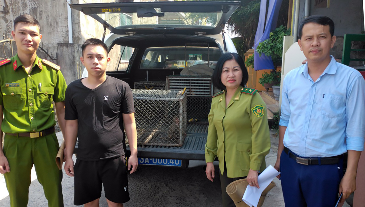 Anh Hoàng Văn Cường (người mặc áo đen) bàn giao cá thể khỉ mặt đỏ cho cơ quan chức năng