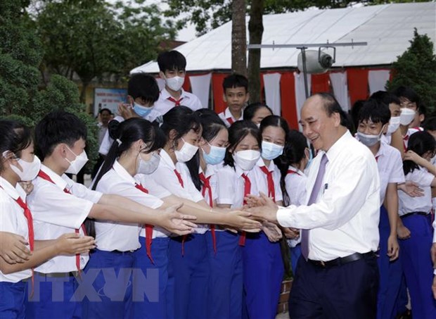 Chủ tịch nước Nguyễn Xuân Phúc với học sinh Trường THCS Triệu Thành. (Ảnh: Thống Nhất/TTXVN)