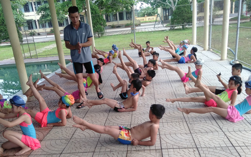 Hướng dẫn trẻ khởi động trước lúc vào học bơi ở trường tiểu học Mai Thuỷ.