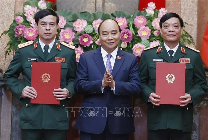 Chủ tịch nước Nguyễn Xuân Phúc, Thống lĩnh các lực lượng vũ trang nhân dân, Chủ tịch Hội đồng Quốc phòng và An ninh trao Quyết định thăng quân hàm từ Trung tướng lên Thượng tướng đối với đồng chí Ngô Minh Tiến và Lương Đình Hồng. Ảnh: Thống Nhất/TTXVN