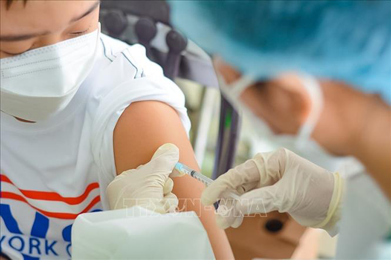 Nhân viên y tế tiêm vaccine cho các em học sinh. Ảnh: Văn Dũng/TTXVN