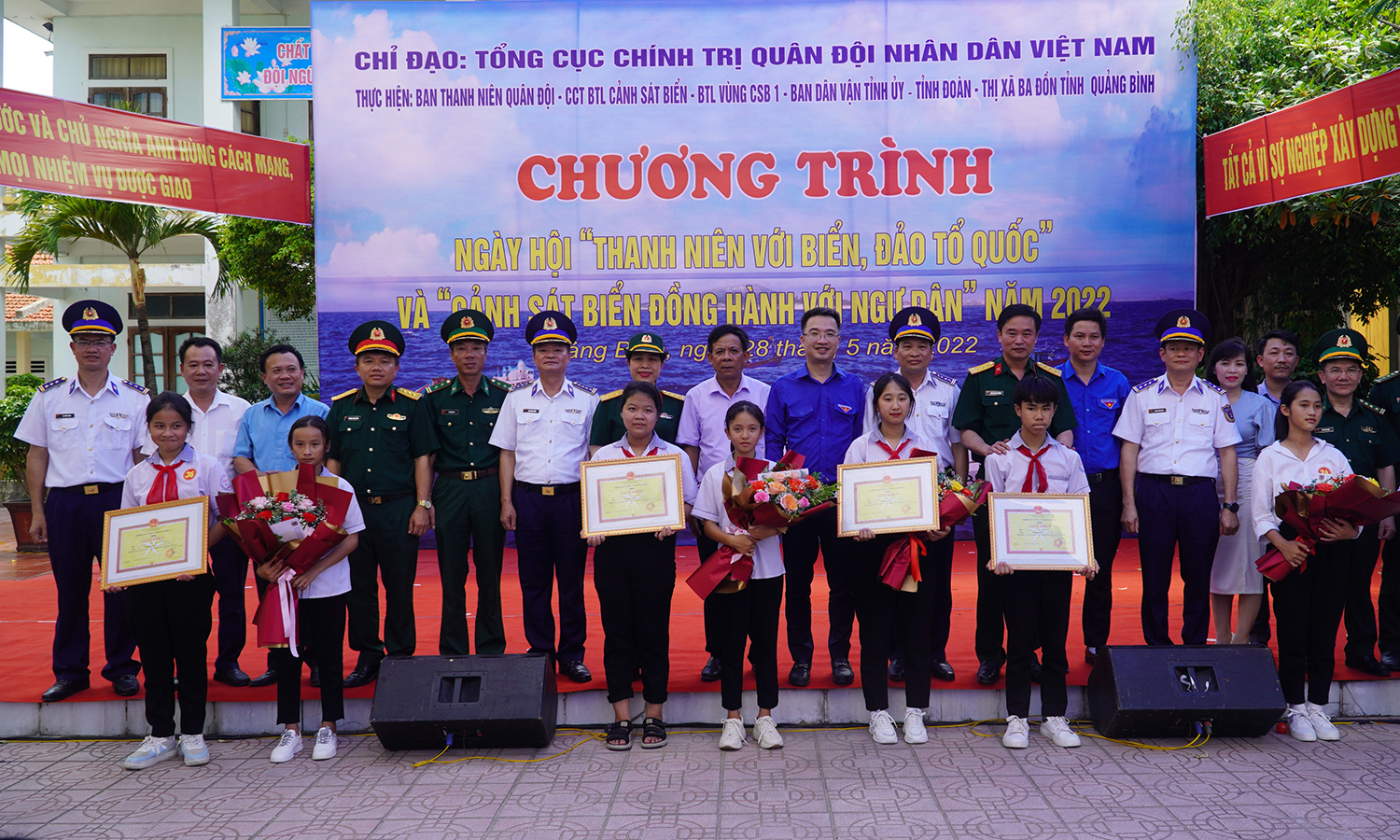 Đại biểu tham dự chương trình chụp ảnh lưu niệm cùng các em học sinh đạt giải trong cuộc thi “Em yêu biển, đảo quê hương”.